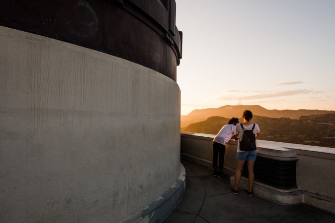 Two people looking at sunset view at Griffith Observatory in Los Angeles