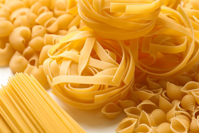 Different pasta on table background, closeup. Dry uncooked whole pasta