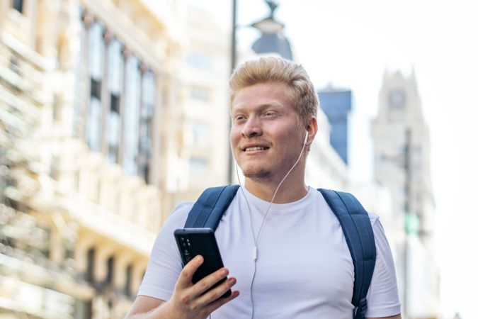 Latino man with albinism using smartphone in the city