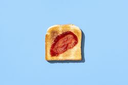 Toast bread with strawberry jam isolated on a blue background
