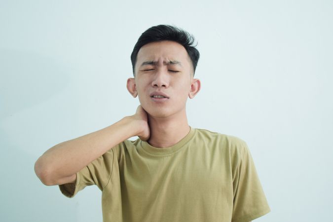 Man touching neck with ache