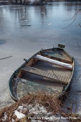 Boat frozen in ice on lake 56QVY0