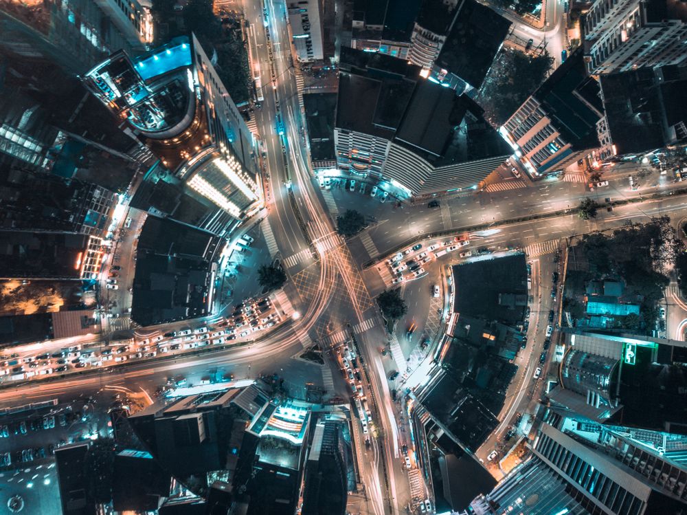 Top view of crossroad highway between city buildings at night