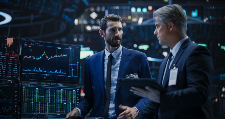 Two Successful Traders Analyzing Real-Time Financial Data and Reports About the State of the Finance Market.