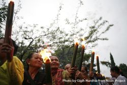 Indonesian women with torches with lit flames marches during Nyepi day on an overcast day 4m9We4