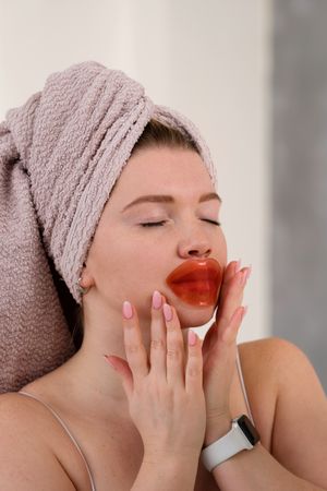 Applying lip-shaped gel mask.
