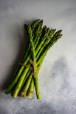 Bunch of wrapped asparagus on marble counter