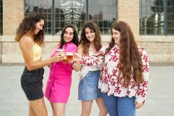 young women friends toasting with a beer and smiling with joy as