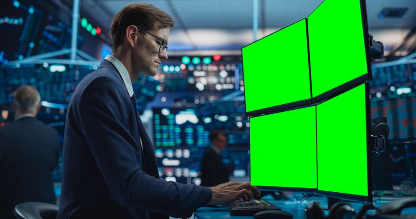 Portrait of Stock Exchange Broker Working on Computer With Green Screen Chromakey On Display, Analyzing Commodities and Exchange Market Charts.