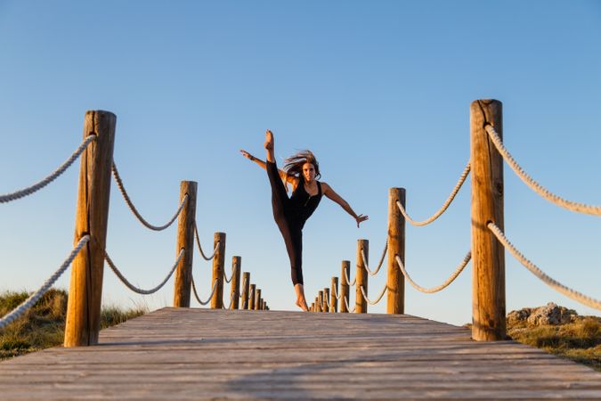 Woman posing in air on footbridge