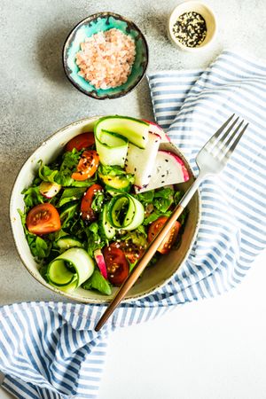 Bowl of healthy vegetable salad on rustic background