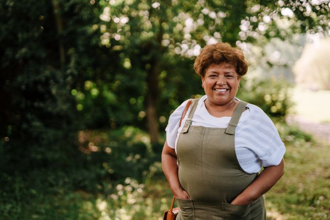 Portrait of older woman in overalls outside