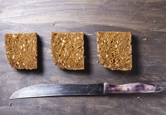 Sliced bread with knife on wooden background