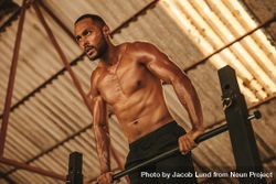 Muscular man doing workout on horizontal bar in fitness studio 0vM3Lb