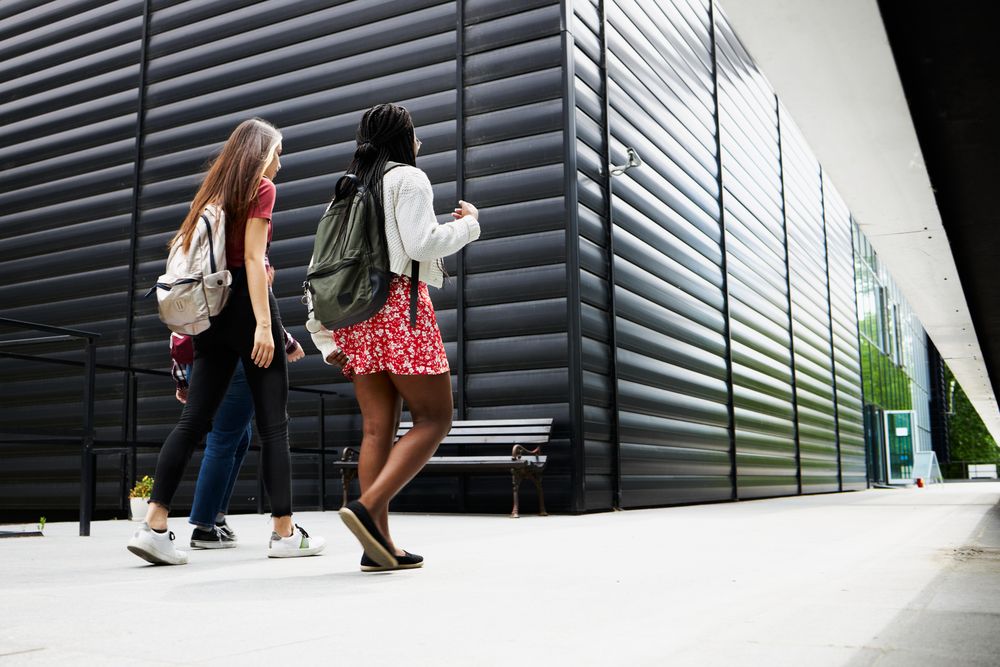Female friends with backpacks walking together