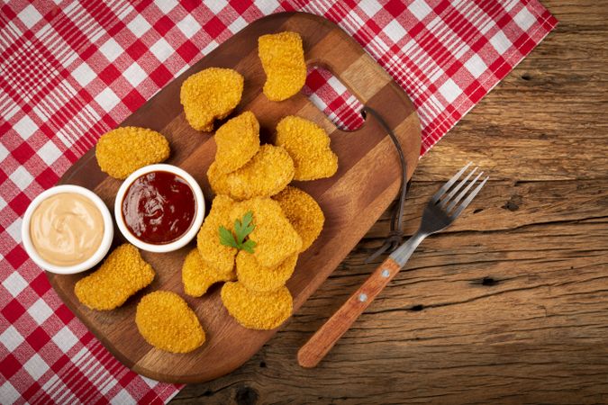 Fried chicken nuggets with ketchp and rose sauce.