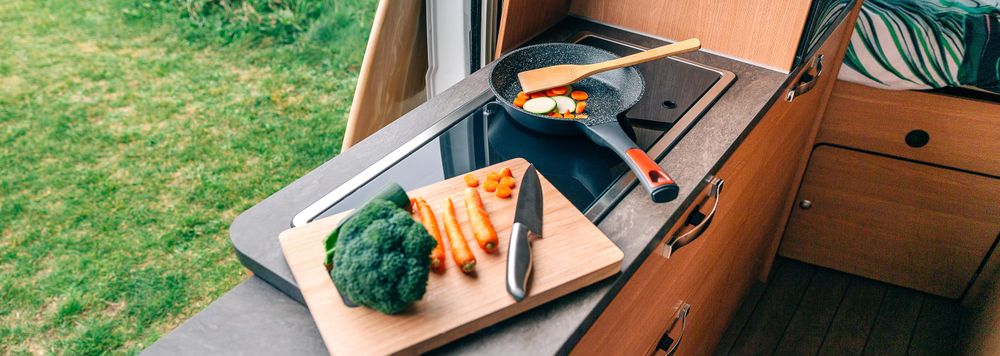 Vegetables being cooked on stove in motorhome vehicle