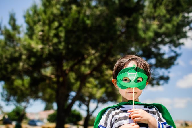 Boy holding green eye mask