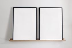 Two vertical picture frames on bamboo wooden shelf