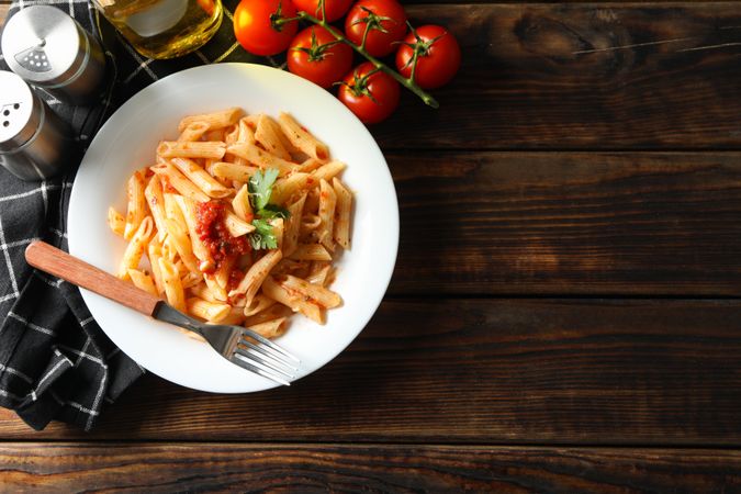 Composition with plate of tasty pasta on wooden background. Cooking pasta