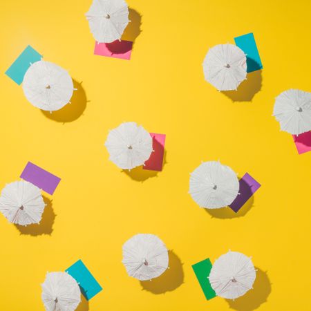 Aerial view of sun umbrellas and multicolored towels on yellow