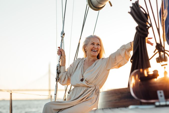 Joyful older woman with long gray hair on a boat