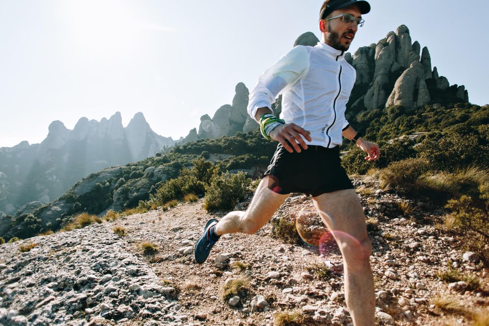 Athletic man jogging in nature on warm day