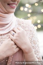 Woman wearing pink hijab and sapphire ring 5XWdG0