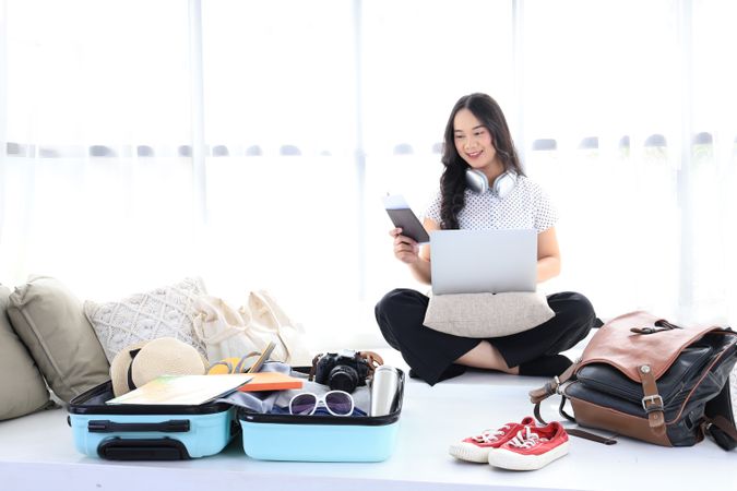 Happy female using computer to planning travel trip and booking tickets or hotel room on web.