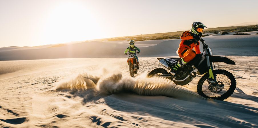 Professional dirt bikers off roading on sand dunes