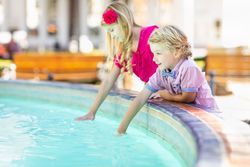 Cute Young Brother and Sister Enjoying The Fountain At The Park