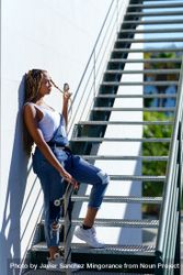 Side of woman playing with hair on stairs with skateboard 0vlqx4