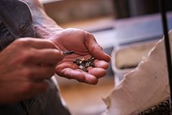 Crop welder examining metal details in garage