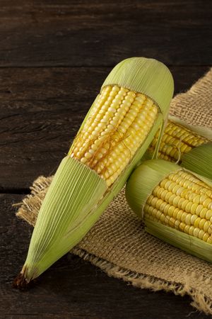 Green corn on the wooden table.
