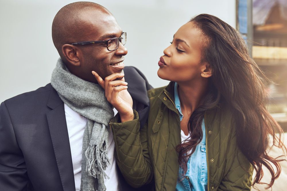 Woman being flirty holding a man’s chin in her hand