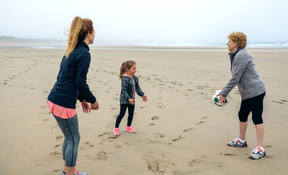 Three generations playing on the beach