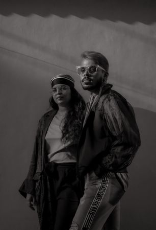 Grayscale photo of a man and woman wearing fashionable outfit