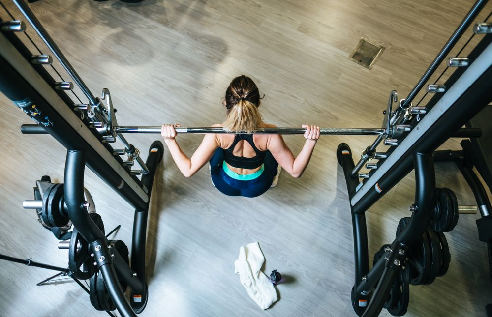 Woman lifting barbell in gym