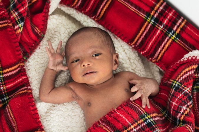 Newborn baby on soft tartan blanket