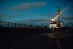Road and lighthouse in evening