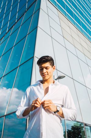Handsome man in button up shirt against skyscraper