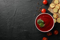 Bowl of tomato soup with crackers, copy space