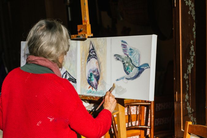 Anonymous woman painting on canvas in garden