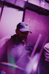 Purple and magenta tinted double exposure of young Black man in baseball cap