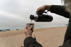 Man pouring coffee from flask into cup