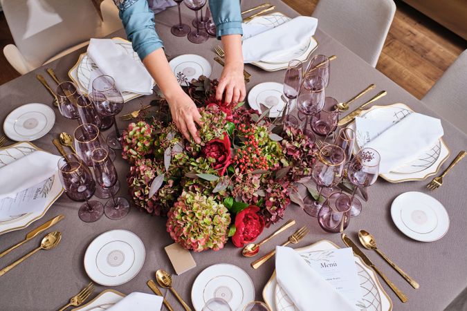 Unrecognizable woman decorating banquet table with flowers