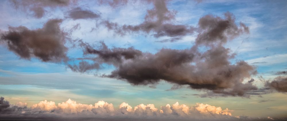 Banner of fluffy light and grey clouds in blue sky