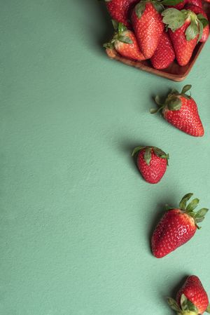 Ripe strawberries with leaves on green table