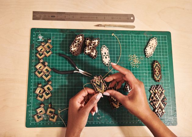 Jewelry designer working with earrings on cutting board