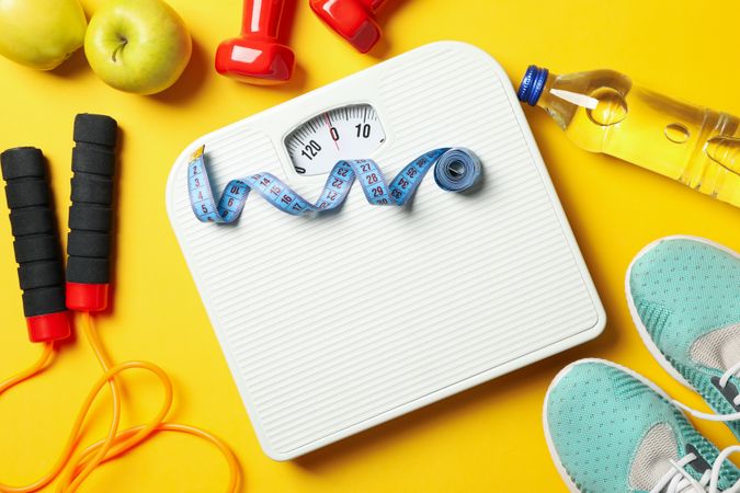 Weight loss or healthy lifestyle accessories on yellow background
